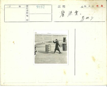 男子肩扛双篮户外行走.jpg