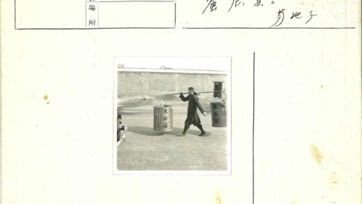 男子肩扛双篮户外行走.jpg