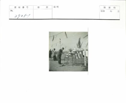 男子鞠躬传统木建筑前.jpg