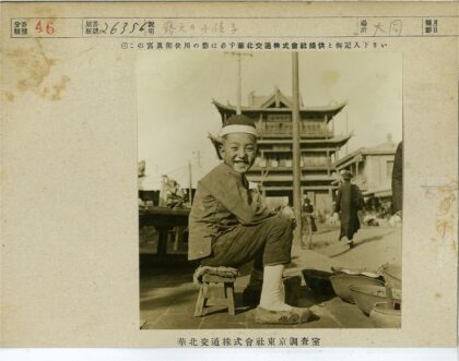 男孩微笑坐凳传统建筑前.jpg