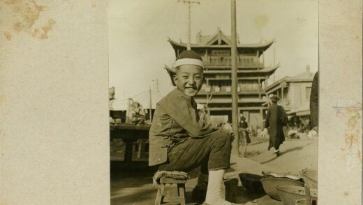 男孩微笑坐凳传统建筑前.jpg