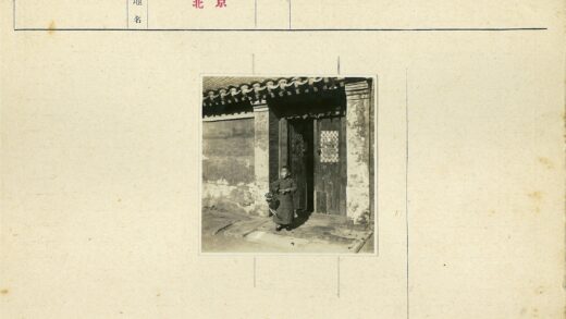 男孩持伞立于古建木门前.jpg