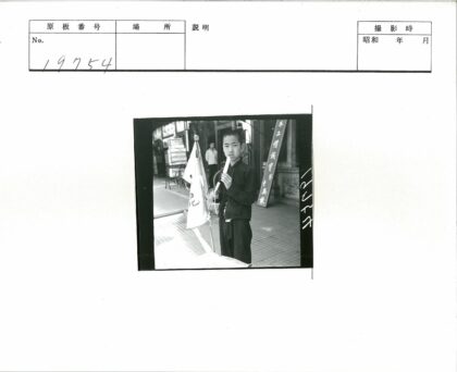 男孩持旗撑伞街头吃冰棍.jpg