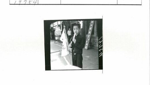 男孩持旗撑伞街头吃冰棍.jpg