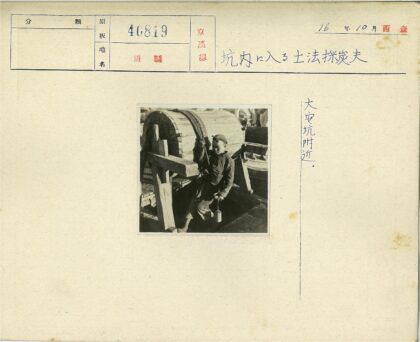 男孩操作木制水井老式取水场景.jpg