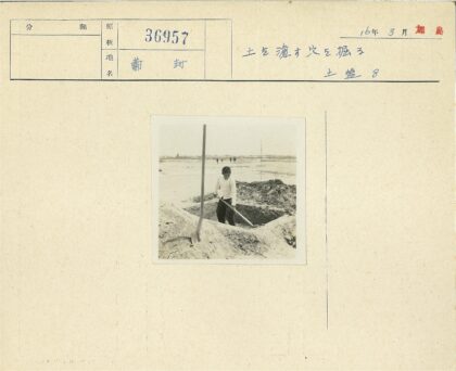 男孩沙地挖土远行人背影.jpg