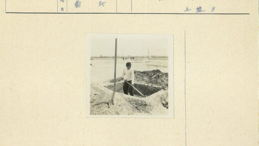 男孩沙地挖土远行人背影.jpg
