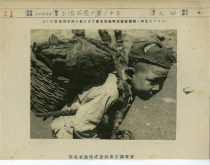 男孩背石篮站岩石地.jpg