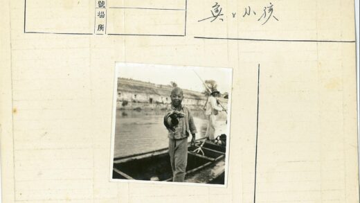 男孩船上持鱼划船风景.jpg