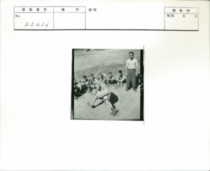 男孩草地摔跤成年男子旁观.jpg