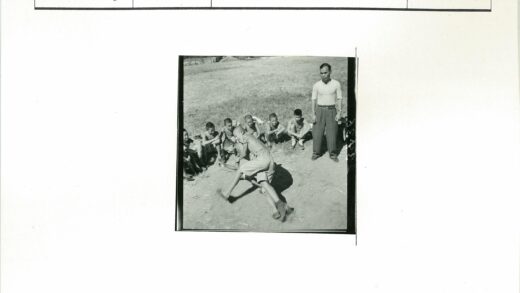 男孩草地摔跤成年男子旁观.jpg