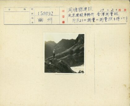 登山者举旗站岩石上.jpg
