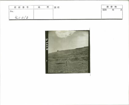 登山者攀爬山坡远眺建筑.jpg