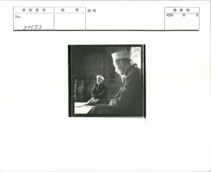 白巾男子坐华丽木雕房.jpg