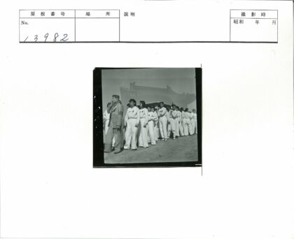 白衣人员与瓦片屋顶建筑合影.jpg