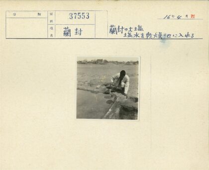 白衣人舀水泥屋背景.jpg