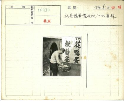 白衣男子提鸡蛋篮站汉字墙旁.jpg