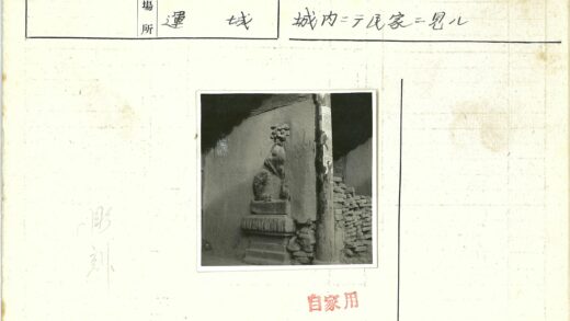 石狮雕像与砖墙木杆.jpg