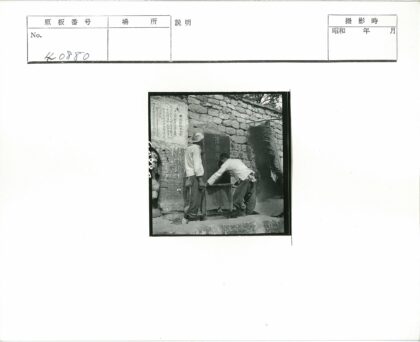 石碑旁两人擦拭铭文.jpg