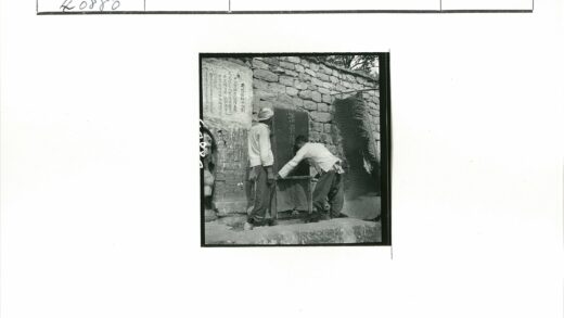 石碑旁两人擦拭铭文.jpg