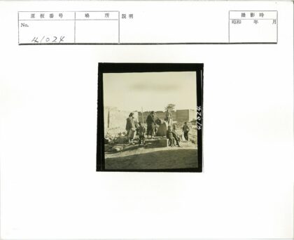 砖墙前人群围井老建筑背景.jpg