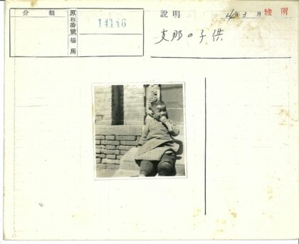 砖墙前孩童坐石阶柱旁.jpg