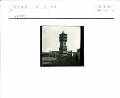 砖墙庭院中的石塔与行人.jpg