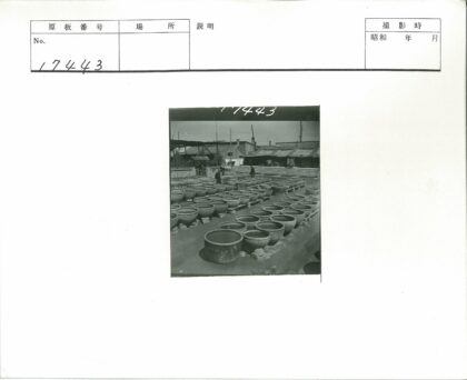 砖墙建筑旁陶罐平台行人.jpg