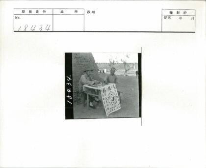 砖墙旁木桌汉字布男子对坐.jpg