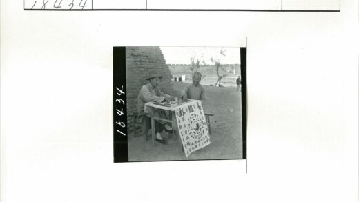 砖墙旁木桌汉字布男子对坐.jpg