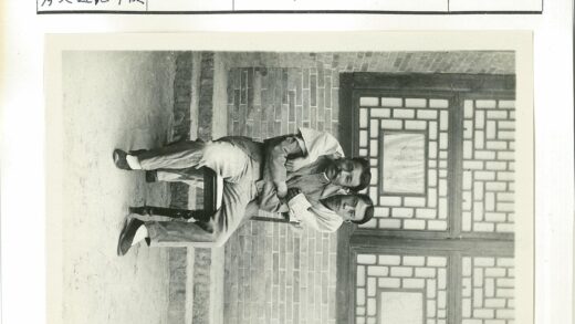 砖墙窗前两男子坐椅.jpg