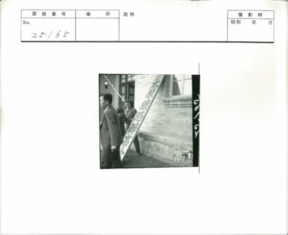 砖房前三人与汉字牌合影.jpg