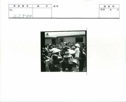 砖房前戴宽檐帽人群.jpg