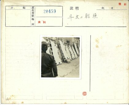 砖房外晾晒兽皮的男子.jpg