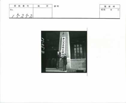 砖房外男子举汉字横幅.jpg