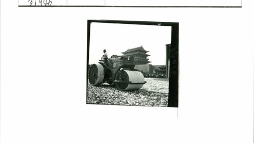 砾石路面压路机操作与多层建筑背景.jpg