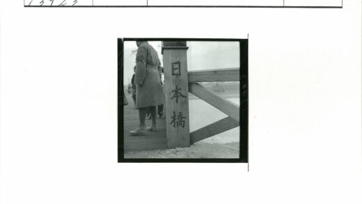 穿大衣者立于刻日文木桥.jpg