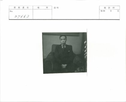 绅士坐深色扶手椅西装照.jpg