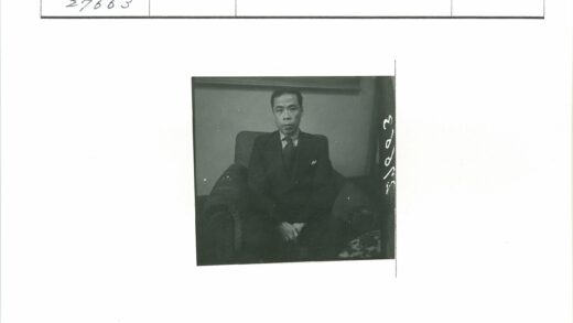绅士坐深色扶手椅西装照.jpg