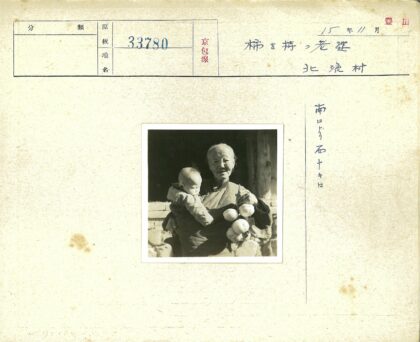 老人抱婴持柿古墙木梁.jpg