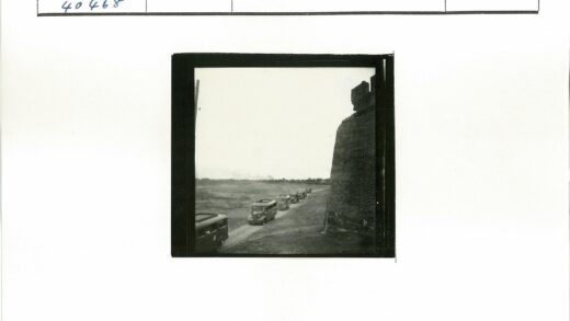 老式公共汽车行驶土路砖墙旁.jpg
