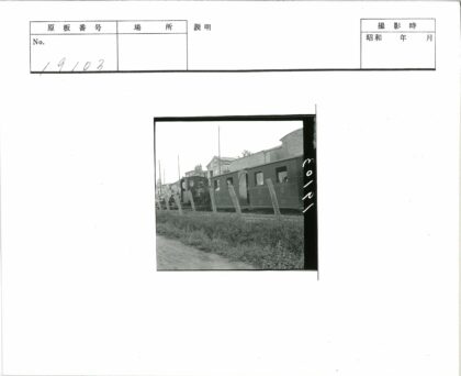 老式火车10号经过建筑与栅栏.jpg