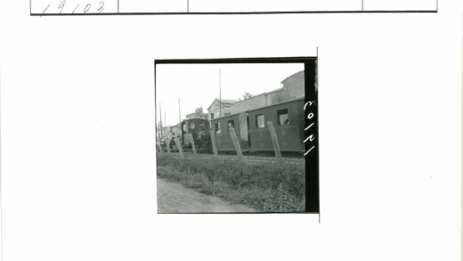 老式火车10号经过建筑与栅栏.jpg
