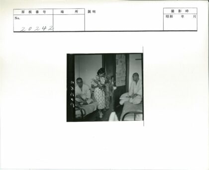 花裙女子持花站门边.jpg
