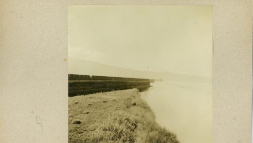 蜿蜒河流与青草山坡景色.jpg