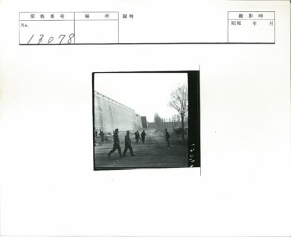 行人走过砖墙土路.jpg
