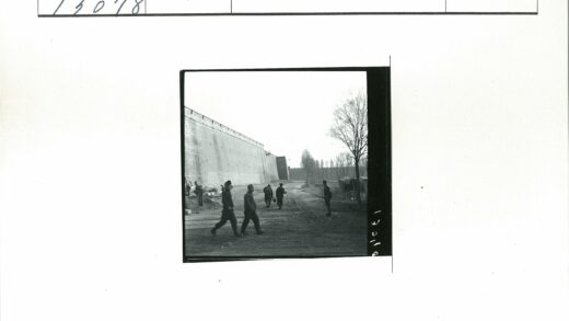 行人走过砖墙土路.jpg