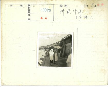 街头女性撑伞行走建筑旁.jpg