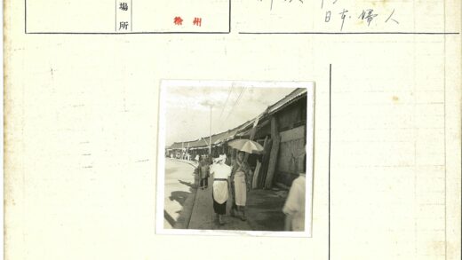 街头女性撑伞行走建筑旁.jpg