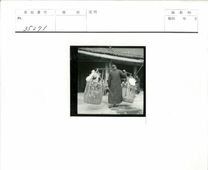 街头提篮人行走瓦房前.jpg